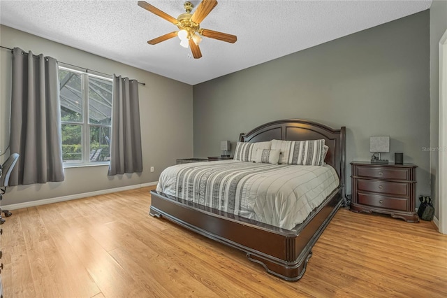 bedroom featuring a textured ceiling, light hardwood / wood-style floors, and ceiling fan