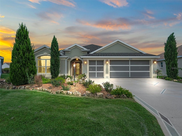 view of front of house with a garage and a yard