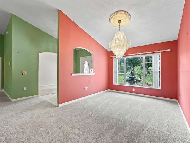 empty room with carpet flooring, an inviting chandelier, a textured ceiling, and lofted ceiling