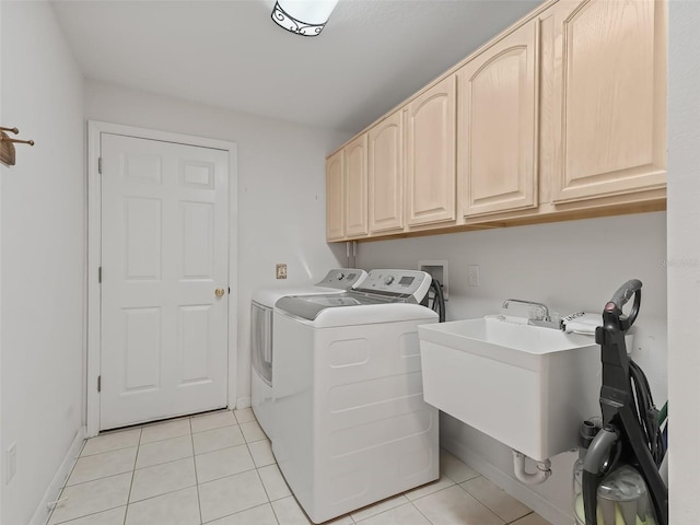 laundry area with sink, cabinets, independent washer and dryer, and light tile patterned floors