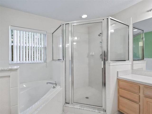 bathroom with shower with separate bathtub and vanity