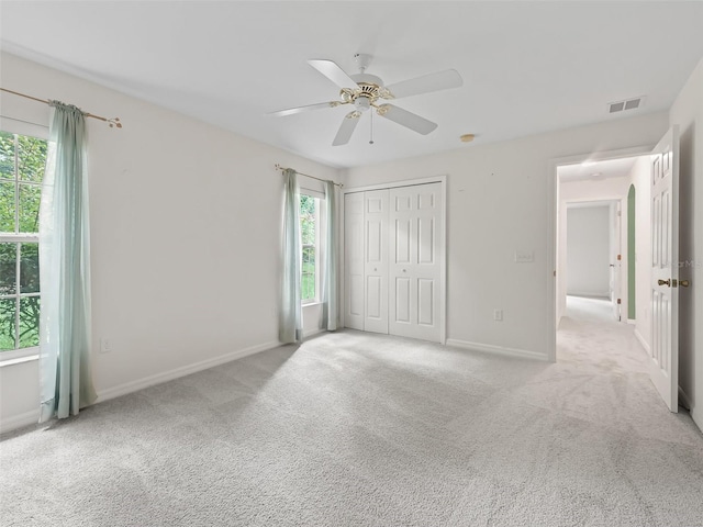 unfurnished bedroom with light carpet and multiple windows