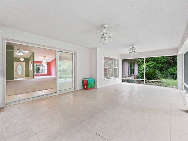 interior space featuring ceiling fan, a textured ceiling, and light tile patterned flooring