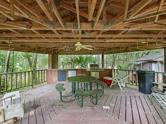 deck with ceiling fan, an outdoor bar, and grilling area