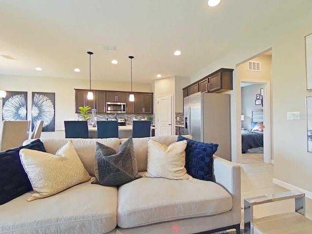 living area featuring recessed lighting, visible vents, and baseboards