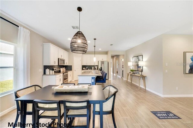 dining room with sink and light hardwood / wood-style flooring