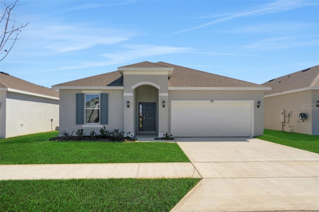 view of front of property with concrete driveway, an attached garage, a front lawn, and stucco siding