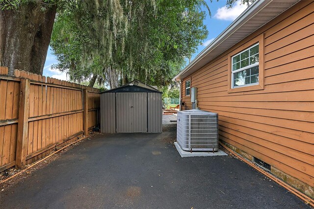 exterior space featuring a storage unit, a patio area, and central air condition unit