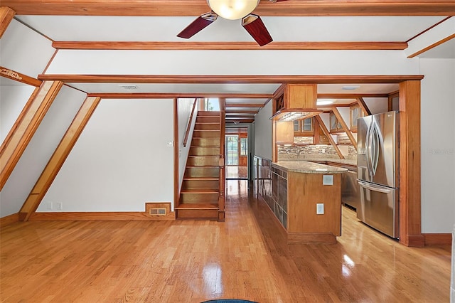 kitchen with light hardwood / wood-style flooring, ceiling fan, stainless steel fridge with ice dispenser, and stone counters