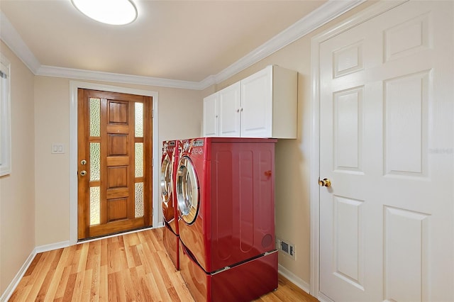 laundry room with light hardwood / wood-style flooring, crown molding, washer and clothes dryer, and cabinets