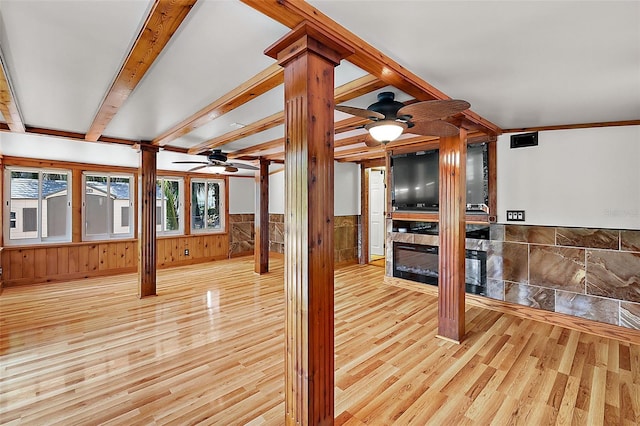 unfurnished living room with ceiling fan, light wood-type flooring, and decorative columns