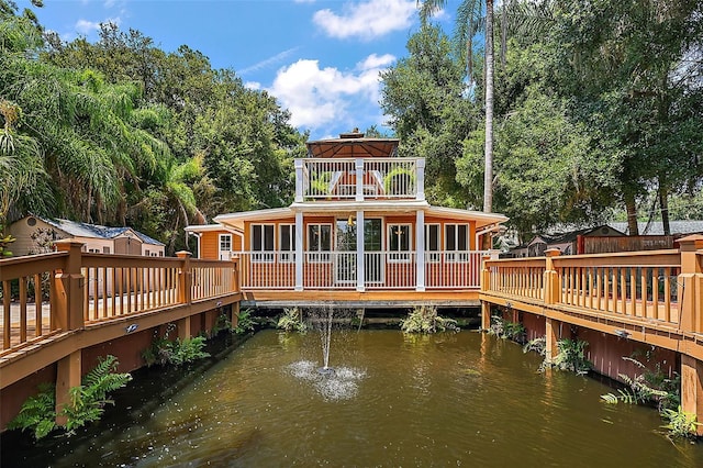 dock area with a balcony and a water view