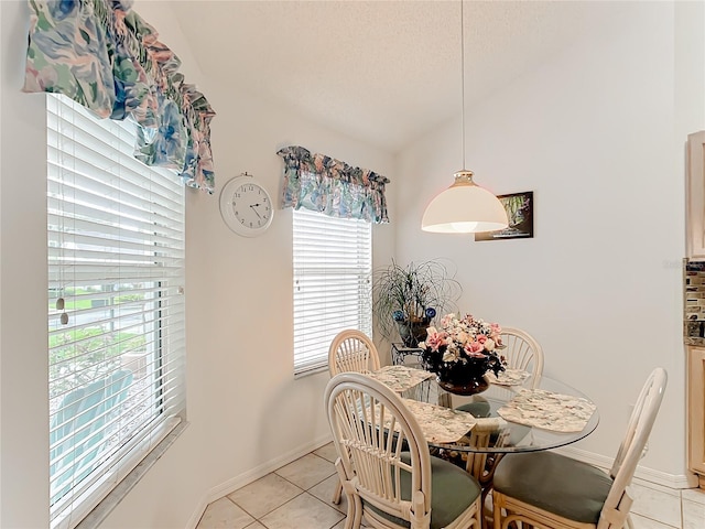 dining space with a textured ceiling and light tile patterned floors