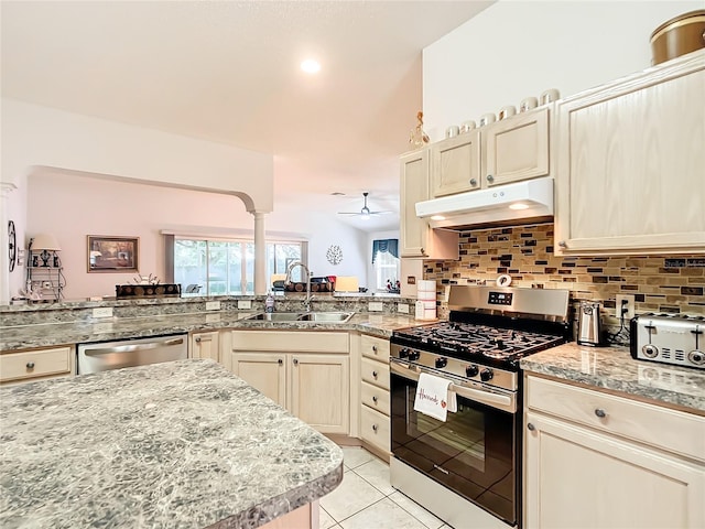 kitchen with light tile patterned floors, appliances with stainless steel finishes, tasteful backsplash, sink, and ceiling fan