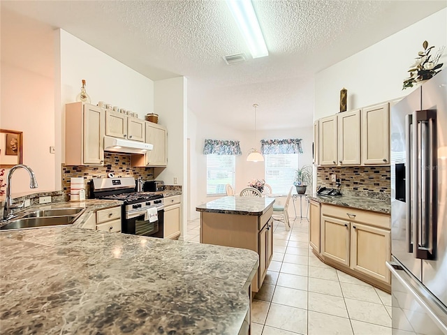 kitchen with a kitchen island, decorative light fixtures, appliances with stainless steel finishes, sink, and decorative backsplash