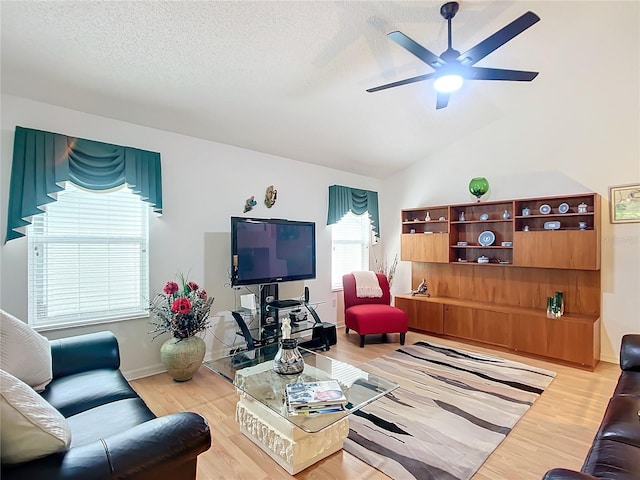 living room featuring a textured ceiling, lofted ceiling, ceiling fan, and light hardwood / wood-style floors