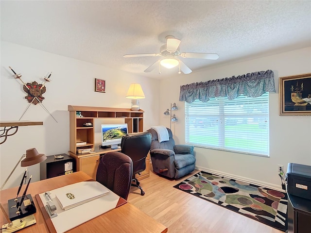 office area featuring light wood-type flooring, ceiling fan, and a textured ceiling