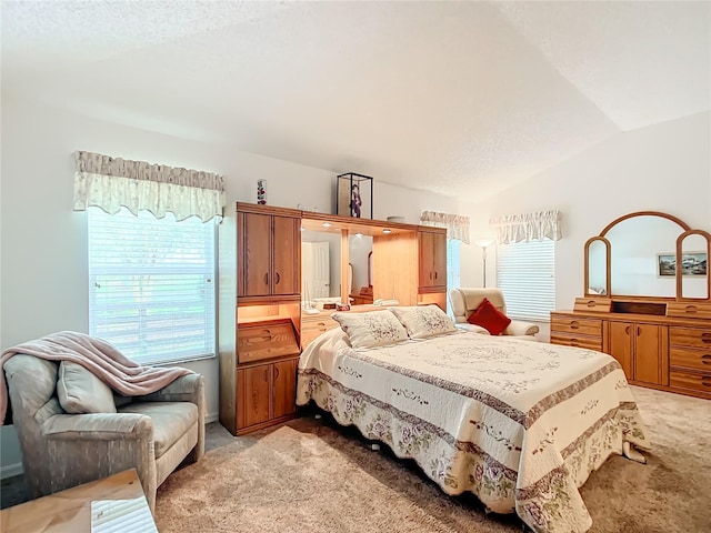 bedroom with lofted ceiling, light colored carpet, and a textured ceiling