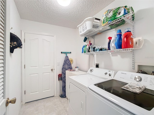 washroom featuring a textured ceiling and washer and clothes dryer