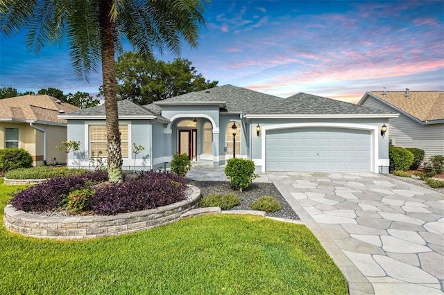 ranch-style home featuring a lawn and a garage