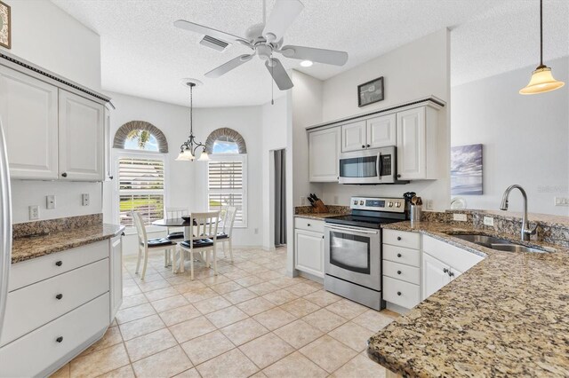 kitchen with light tile patterned floors, appliances with stainless steel finishes, sink, and a textured ceiling