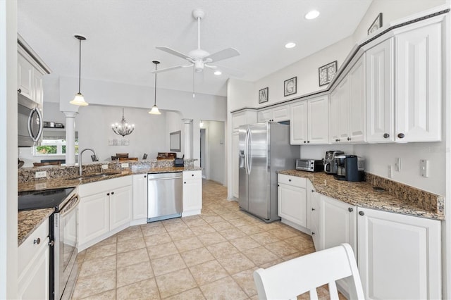 kitchen featuring light tile patterned flooring, hanging light fixtures, stainless steel appliances, kitchen peninsula, and white cabinets