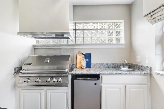 kitchen featuring refrigerator, island range hood, white cabinets, and sink