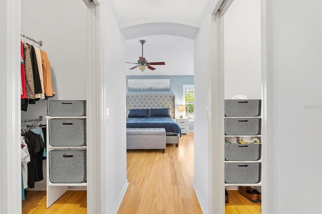 hallway with light hardwood / wood-style floors and lofted ceiling