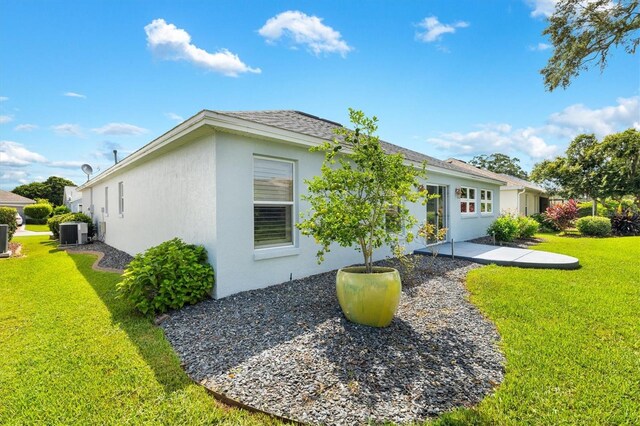 back of house with a lawn, central AC unit, and a patio area