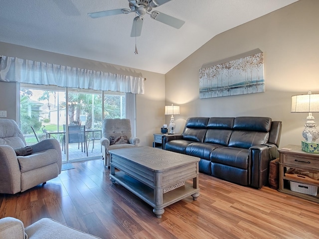 living area featuring lofted ceiling, ceiling fan, a textured ceiling, and wood finished floors