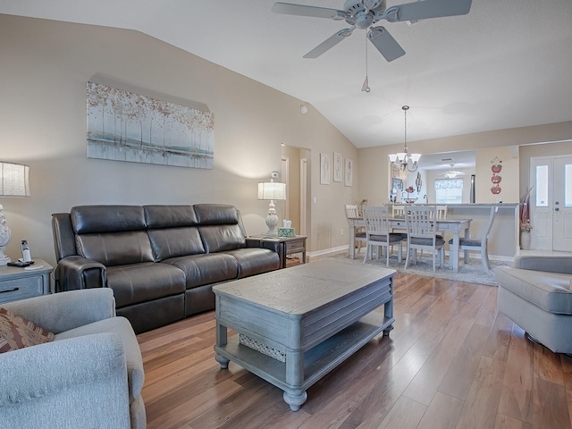 living area with ceiling fan, vaulted ceiling, and wood finished floors