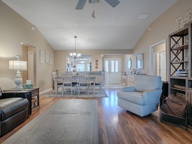 living room featuring hardwood / wood-style flooring, vaulted ceiling, and ceiling fan with notable chandelier