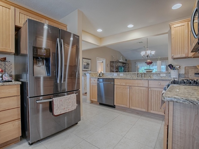 kitchen featuring appliances with stainless steel finishes, lofted ceiling, kitchen peninsula, and light brown cabinets