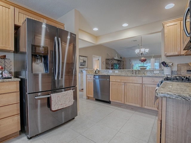 kitchen featuring pendant lighting, appliances with stainless steel finishes, light brown cabinets, a sink, and a peninsula