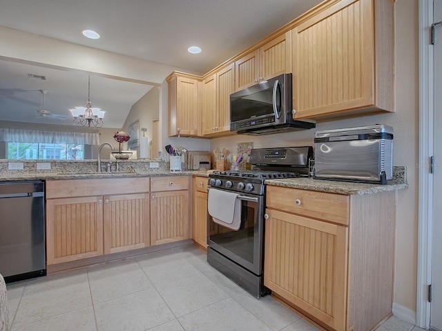 kitchen with decorative light fixtures, light brown cabinetry, appliances with stainless steel finishes, a sink, and a peninsula