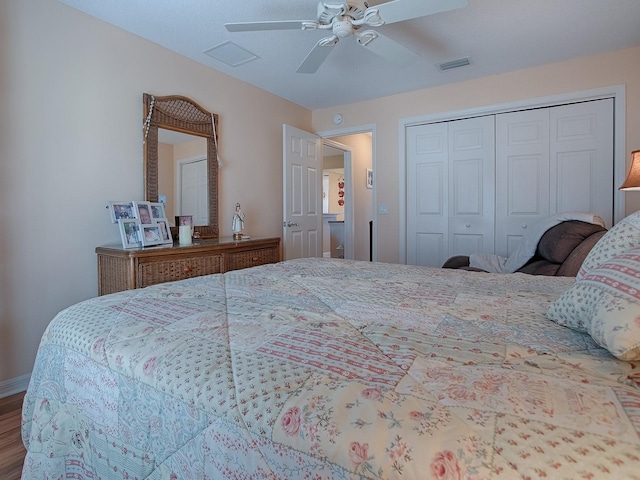 bedroom with ceiling fan, wood-type flooring, and a closet