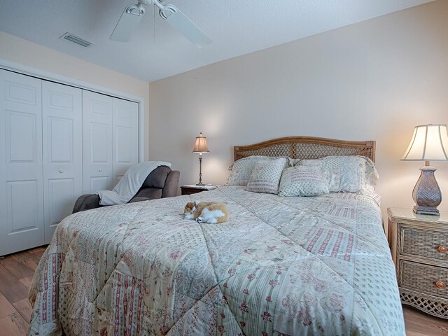 bedroom with ceiling fan, a closet, and hardwood / wood-style floors