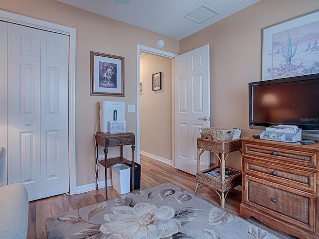 bedroom with a closet, visible vents, light wood-style flooring, and baseboards