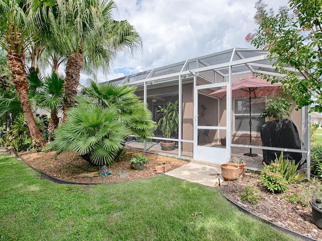 back of house featuring a lawn and glass enclosure