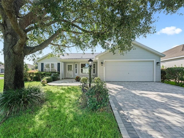 ranch-style house featuring a garage and a front lawn