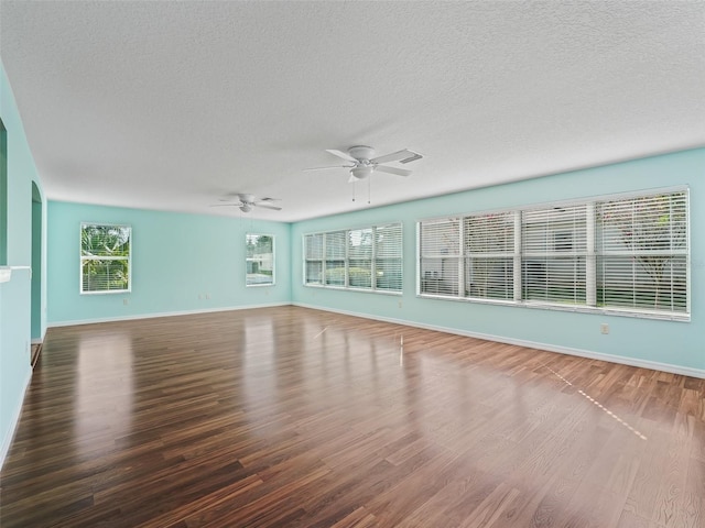 unfurnished room featuring ceiling fan, dark hardwood / wood-style floors, and a textured ceiling