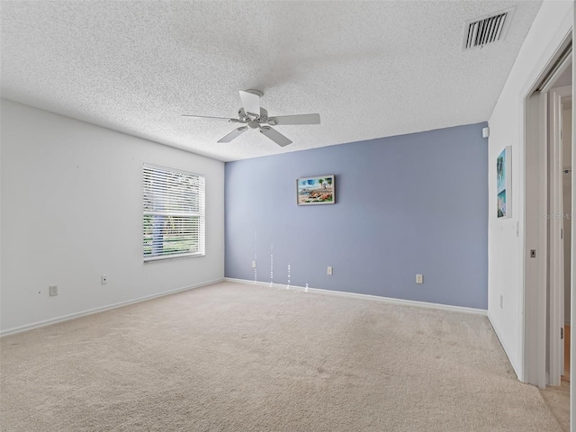 carpeted empty room featuring ceiling fan and a textured ceiling