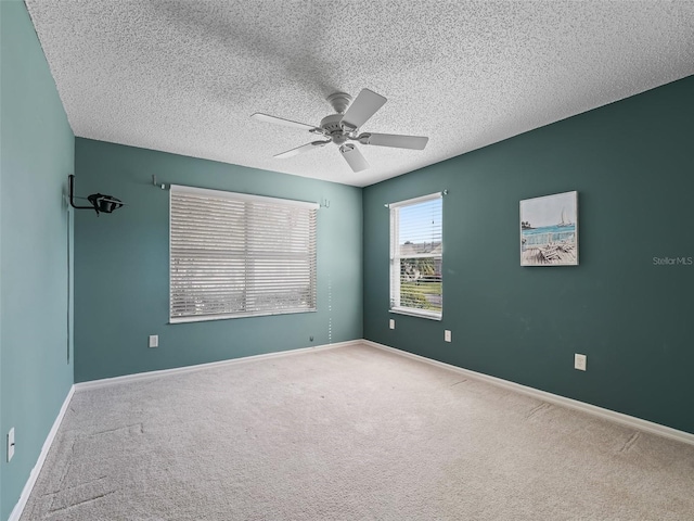 unfurnished room featuring ceiling fan, carpet, and a textured ceiling