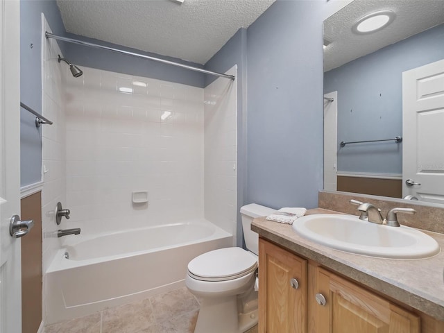 full bathroom featuring tiled shower / bath combo, vanity, toilet, and a textured ceiling