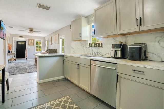 kitchen featuring tasteful backsplash, dishwasher, cream cabinets, ceiling fan, and sink