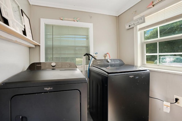 clothes washing area with ornamental molding and washing machine and clothes dryer