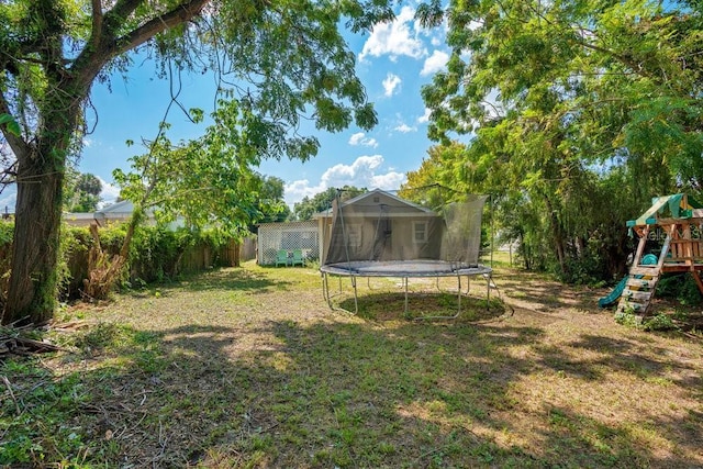 view of yard featuring a playground and a trampoline