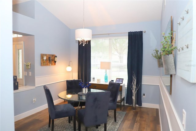 dining room with lofted ceiling, an inviting chandelier, baseboards, and wood finished floors