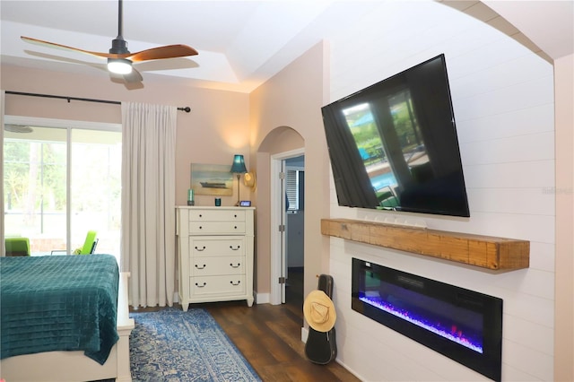 bedroom with ceiling fan, a raised ceiling, and dark wood-type flooring