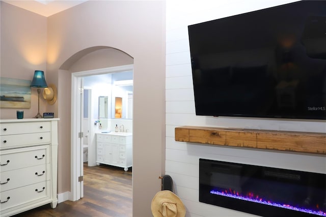 living room with dark wood-style flooring and a glass covered fireplace